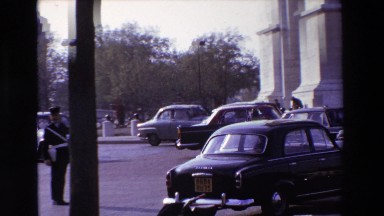 1969: view of a busy street and intersection in france filled with cars