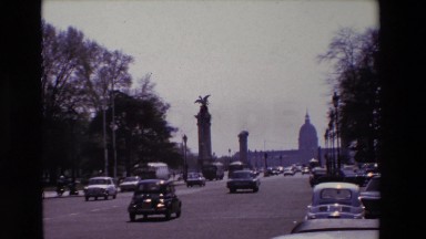 1969: cars and busses drive down a somewhat busy road PARIS, FRANCE