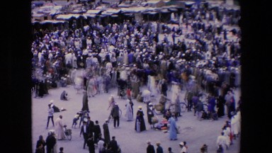 1971: crowd gathers in open marketplace in front of rows of tents