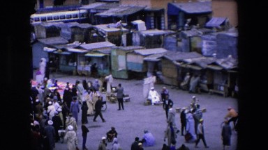 1971: hundreds of people milling about what looks to be an indian chantey town