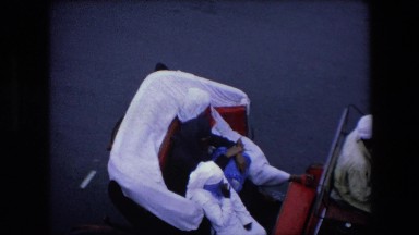1971: three women in burkas riding in a horse-drawn coach down a paved street
