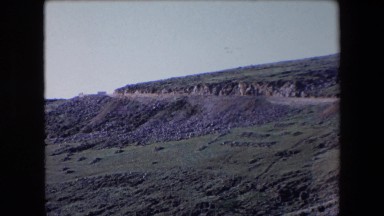1971: view of a road in the desert curving downhill toward a canyon ALGERIA