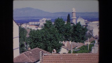 1971: a scenic view of a historical type town on a sunny day with mountains