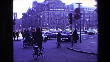 1967: Man Riding Bike Through Busy Amsterdam Street