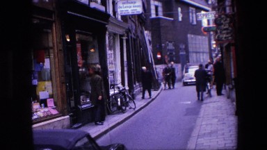 1967: Busy Street in European City with Cars Bicycles Motorcycles Business Men