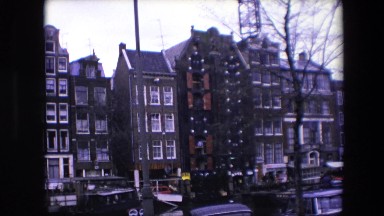 1967: Young Adult Male Standing in Window Opening Leaning Against Railing