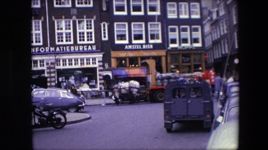 1967: a busy circa 1960s european street, possibly amsterdam, with draft horses