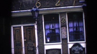 1967: looking into a dark closed window with a half opened curtain AMSTERDAM