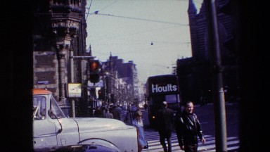 1967: Busy Street Zoom In Building Tall Statue Top Amsterdam, Netherlands