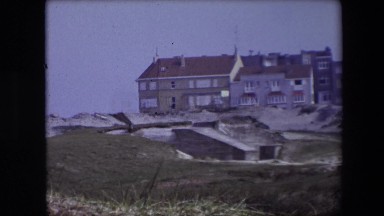 1967: Large Stone Building on a Hill with Grass and Houses in Calais, France