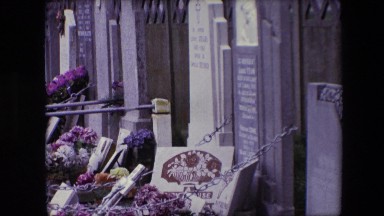 1967: a view of a cemetery with various tombstones chained to a wall