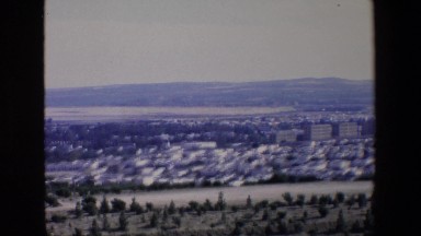 1967: a sweeping view of a city nestled in the foothills of a mountain range