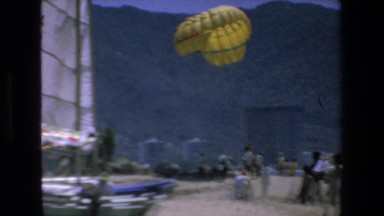 1972: people gathered around to watch a skydiver. MAZATLAN MEXICO