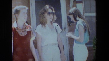 1981: three beautiful young girls standing in front of a buildings LANSING
