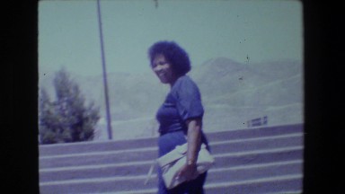 1981: two women walking up steps against a mountainous background LANSING