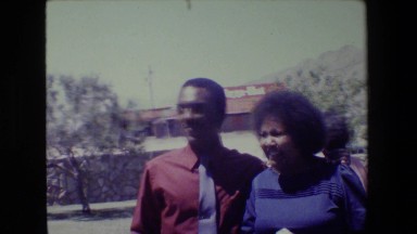 1981: large group of people walking around outside talking and smiling LANSING