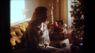 1981: young woman on christmas morning getting ready to open presents. LANSING