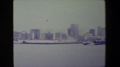 1981: panoramic city skyline with people on boat in harbor looking at bridge