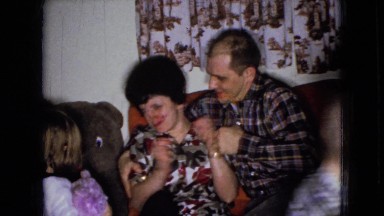 1965: A Man and Woman Wrestling on the Couch as He Tries to Give Her a Kiss