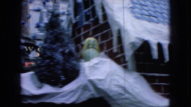 1965: car passing by a busy street area with decoration WELLSBURG IOWA