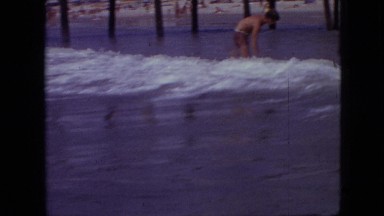 1968: beachgoers play in waves near shore and children ride on floats MISSOURI