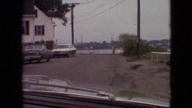 1968: car driving along a dirt road next to a lake shore MISSOURI