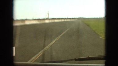 1968: cars moving highway speeding empty road grasses corner wiper sunny weather