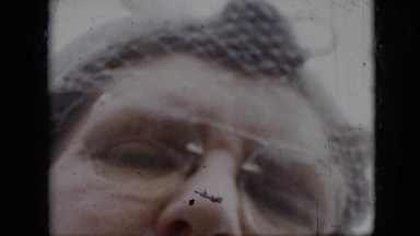 1957: Woman's Face with White Netting Veil Over Forehead, Wearing Glasses
