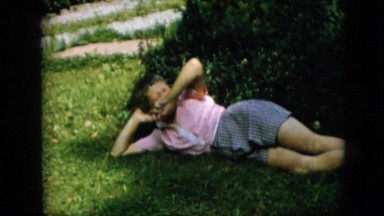 1957: boy lying grass rolling happy singing wearing shoes having fun