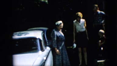 1957: people standing near a vehicle talking and enjoying being around