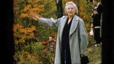1957: lady addressing and describing the natural beauty in the nature in coat