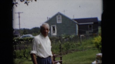 1957: a garden and cape cod style house with table set for celebration