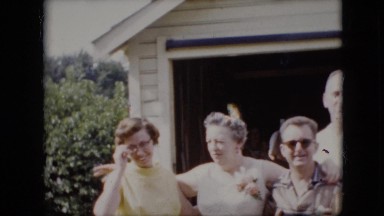 1969: adults gathering for a picture with older woman wearing a corsage