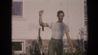 1964: proud man holding up fishing catch PHILADELPHIA PENNSYLVANIA