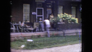1964: happy people are standing in front of the house and waving hands