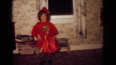 1965: small little cute girl wearing red frock playing doll sitting window
