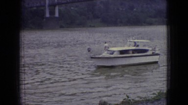 1965: a leisure boat passes several small speed boats on a river