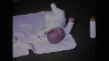 1966: cute little baby lying on sheet ground