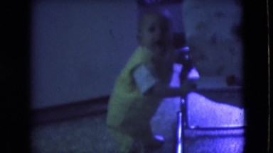 1966: a baby dressed in yellow using a chair to stand ATHENS OHIO