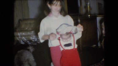 1966: an older sister helps a toddler walk across the living room floor ATHENS