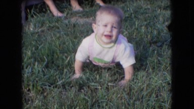 1966: a beautiful baby crawling on the grass and some children playing with dog