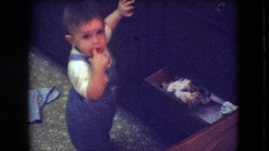 1966: cute little toddler is playing and pulling stuff out of drawer