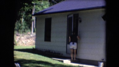 1966: woman opening her front door to check on something. ATHENS OHIO
