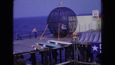 1966: stunt man rides motorcycle in ball-shaped cage on the dock. NEW JERSEY