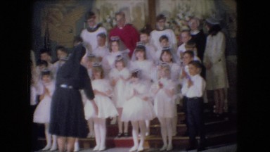 1966: a nun preparing candidates in white dresses for communion in a church
