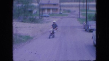 1966: a young man riding a little scooter up the dirt road OHIO