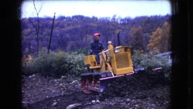 1966: man driving bulldozer, doing flatwork during the fall OHIO