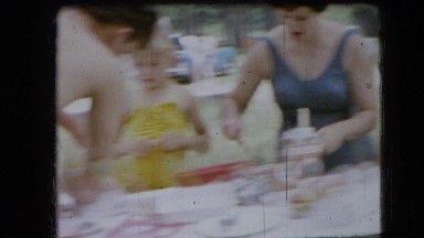 1966: picnickers in bathing suits setting up a pavilion table