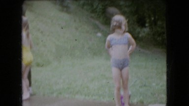 1966: a family playing in the yard with a garden hose, driving down the road.