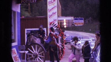 1974: man in traditional native american headdress speaks with man on horse